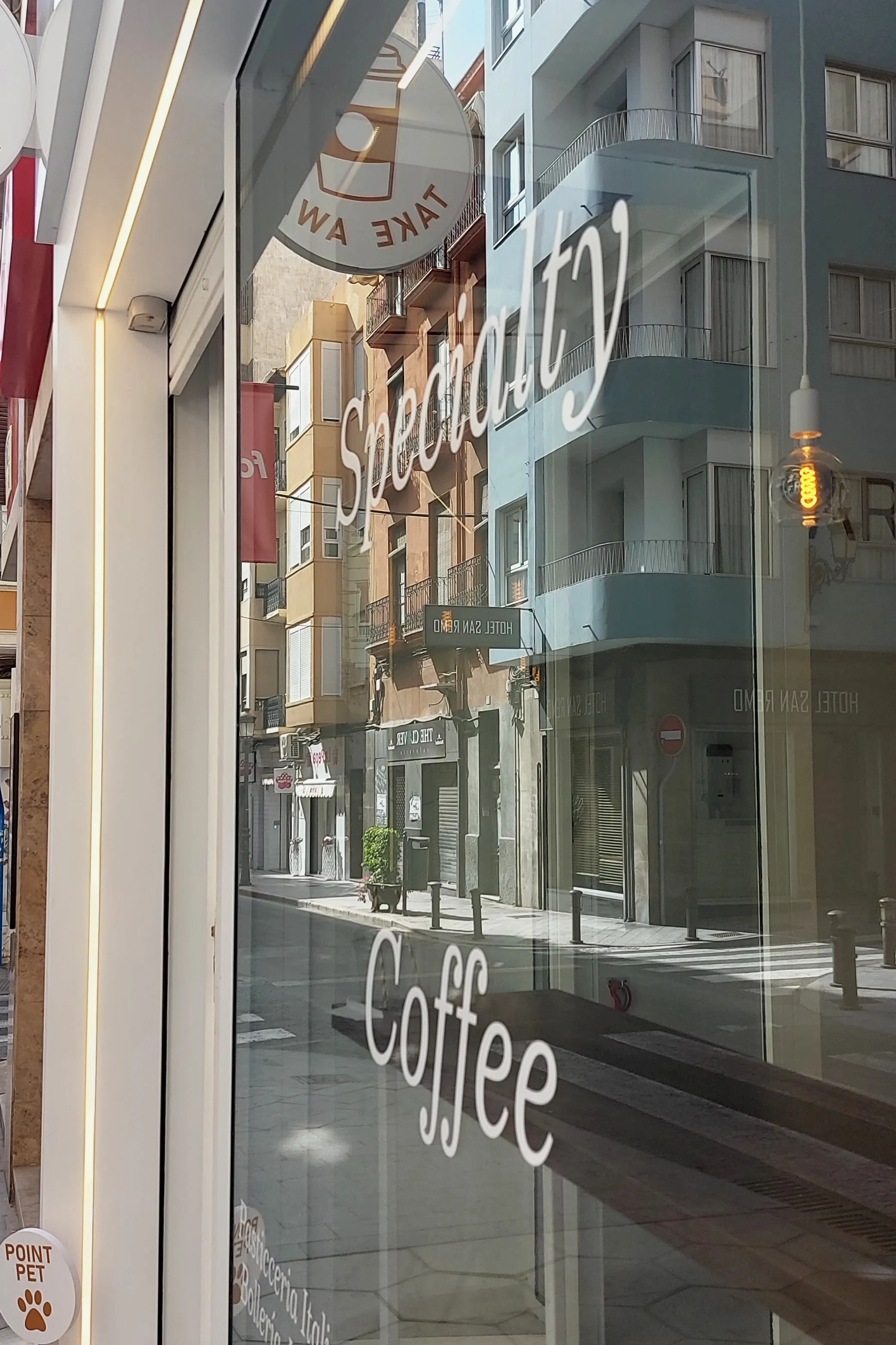 Escaparate de Point Bianco con las letras «Specialty Coffee» y la calle al otro lado del cristal
